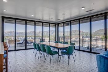 A conference room with a table and chairs and a view of the mountains outside.